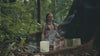 Founder of Terratone meditating with crystal singing bowls surrounded by nature and incense smoke.